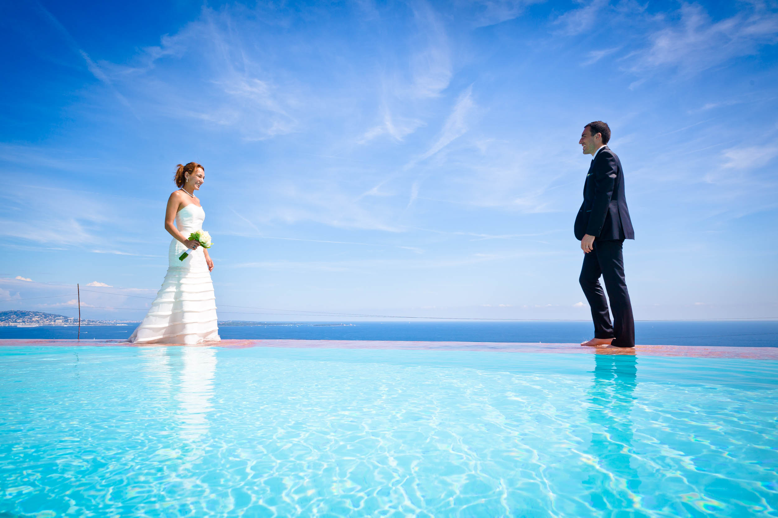 couple en tenue de mariage au bord de la piscine de la maison du Palais Bullies, avec vue sur mer